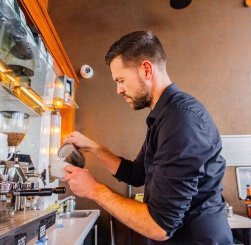 Barista in coffee shop making coffee