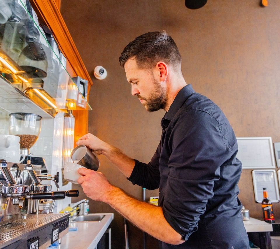 Barista in coffee shop making coffee