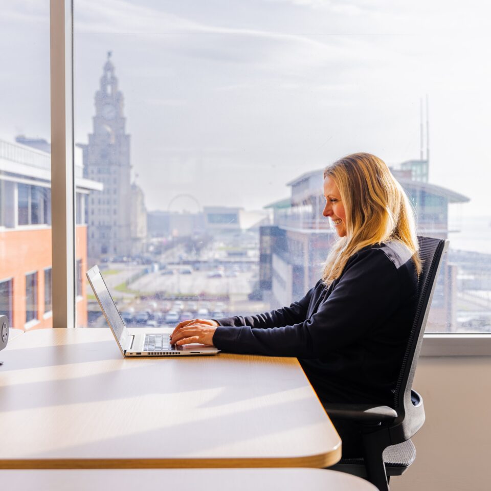 Person working with a view of the Liver Building